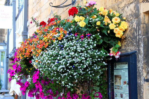 Floral bouquet hanging from wall along High St. Chipping Campden, England.