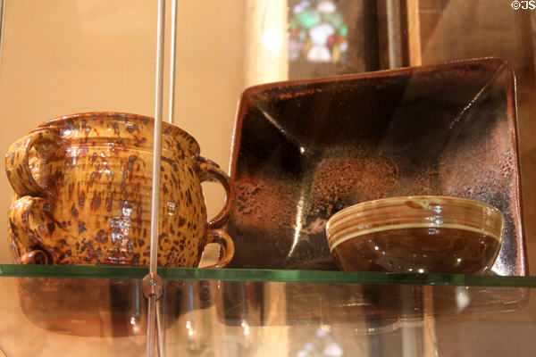 Earthenware & glazed drinking cup (c1930) by Michael Cardew, stoneware square dish (c1970-74) by Ray Finch & earthenware bowl (after 1954) by Sidney Tustin at Court Barn Museum. Chipping Campden, England.