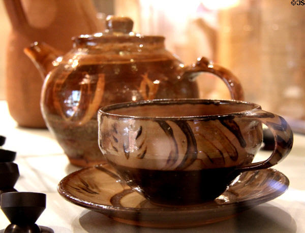 Earthenware teacup & saucer (c1930) & earthenware teapot (c1930) both by Michael Cardew at Court Barn Museum. Chipping Campden, England.