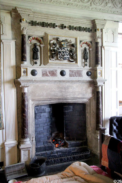 Ornate marble fireplace with coat-of-arms above mantel shelf at Chastleton House. Moreton-in-Marsh, England.
