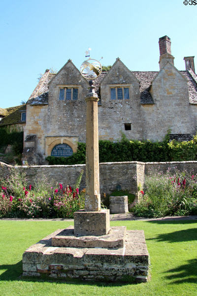 Sundial on pedestal standing in garden in front of Snowshill Manor. England.