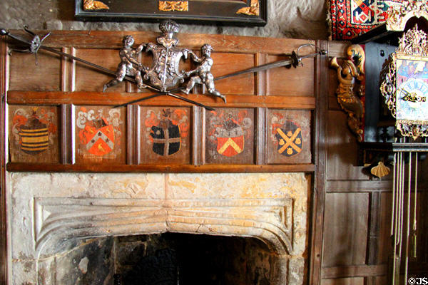 Fireplace mantel decorated with crossed swords & coats of arms at Snowshill Manor. England.