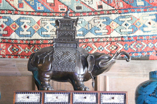 Antique statue of elephant with ornate howdah (saddle) on its back at Snowshill Manor. England.
