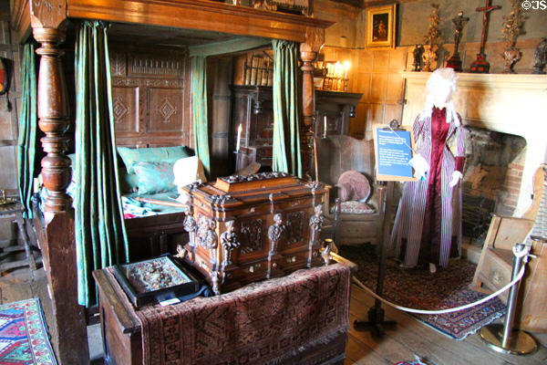 Bedroom with canopy bed, antique ornate chest & item from dress collection at Snowshill Manor. England.