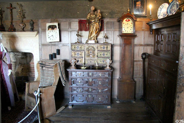 Bedroom with porter's chair, ornate chest and other antique furnishings at Snowshill Manor. England.