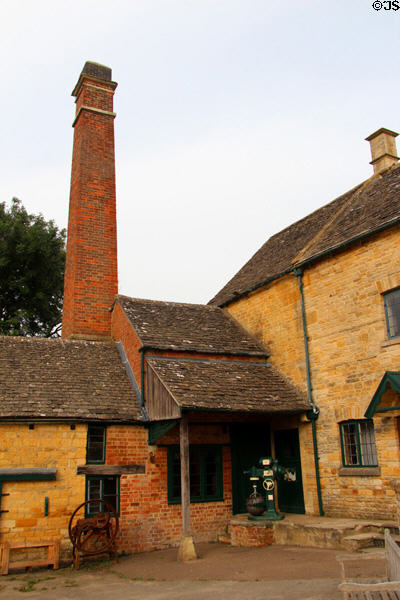 Tall red brick chimney of Old Mill. Lower Slaughter, England.