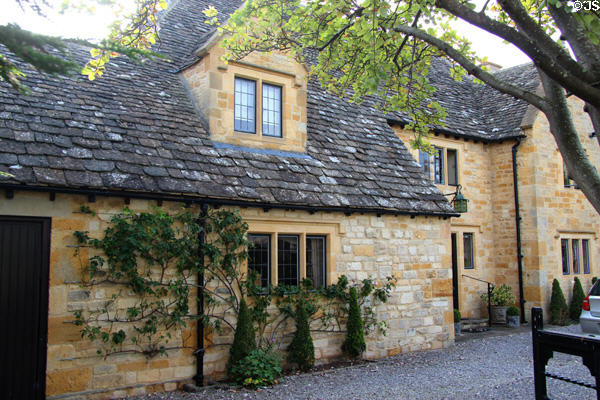 Large Cotswold stone home with dormer window piercing slate roof. Stanton, England.