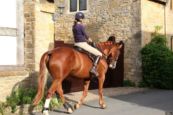 Horse back rider on village street. Stanton, England.