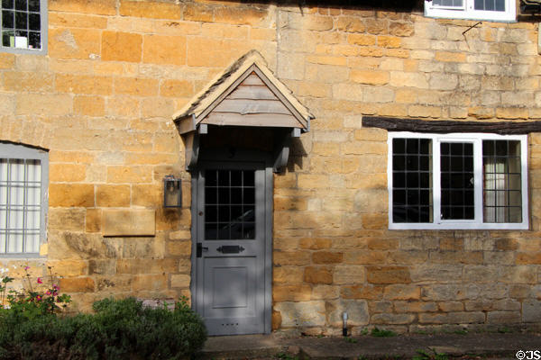 Covered entrance to home lining village street. Stanton, England.