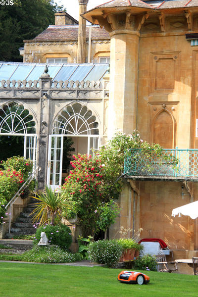 Steps to Orangery with flowering shrubs on each side. Moreton-in-Marsh, England.