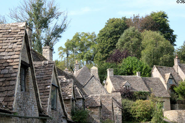 Steep slate roofs on weavers' cottages & other homes along Arlington Row. Bibury, England.