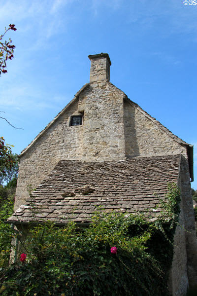 Larger antique building with steeply sloped overhang. Bibury, England.
