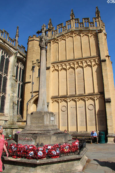 War memorial (1918) built by William D Gough, standing on SW side of Church of St John Baptist with rolls of honor carved into face of church porch. Cirencester, England.