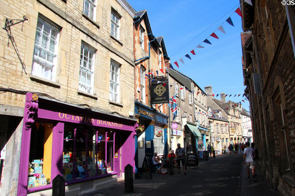 Shops lining medieval narrow street in historic center. Cirencester, England.