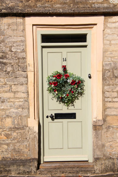 Floral wreath on door along Coxwell St. Cirencester, England.