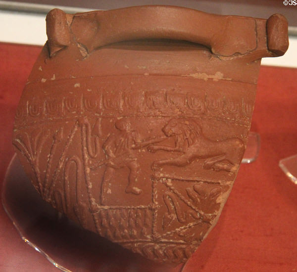 Samian ware sherd decorated with scenes of man spearing lion at Corinium Museum. Cirencester, England.