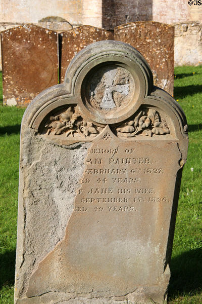 Carving on tombstone of married couple dated in 1820's in cemetery of St Peter & St Paul. Northleach, England.