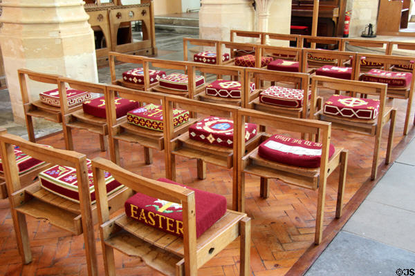 Wooden chairs, designed by Basil Spence & made by Gordon Russell, with needlepoint cushions typically made by ladies of a parish in Church of St Peter & St Paul. Northleach, England.