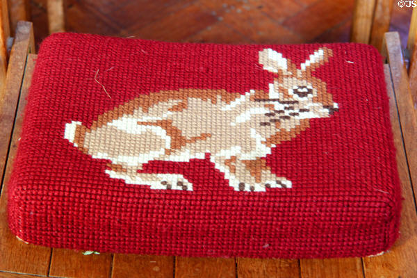 Needlepoint cushion with rabbit image on chair in Church of St Peter & St Paul. Northleach, England.