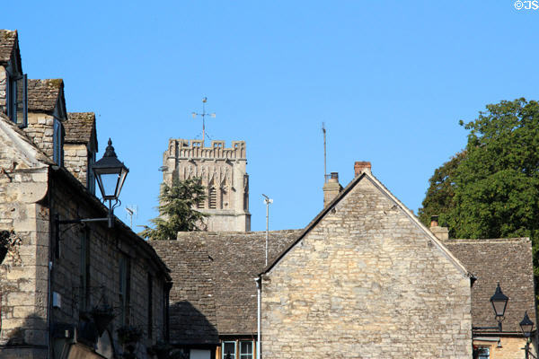 Roofs on vintage buildings with tower of Church of St Peter & St Paul in background. Northleach, England.