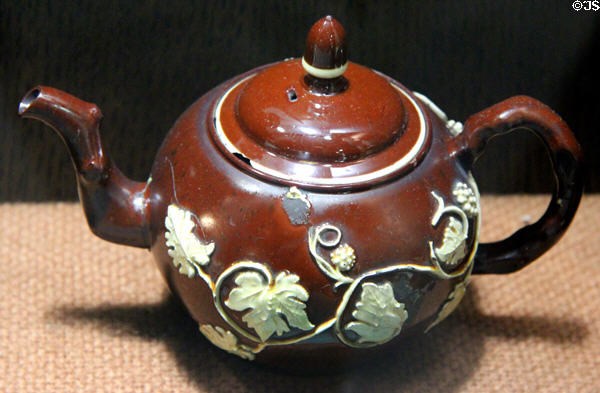 Red earthenware teapot with applied molded relief decoration (c1740-60) made in Straffordshire at Potteries Museum & Art Gallery. Hanley, Stoke-on-Trent, England.