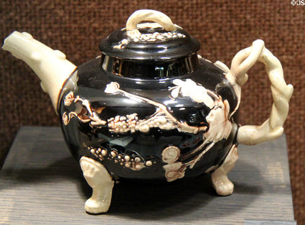 Black iron rich colored red earthenware teapot with applied white molded relief decoration (c1755-65) made in Straffordshire at Potteries Museum & Art Gallery. Hanley, Stoke-on-Trent, England.