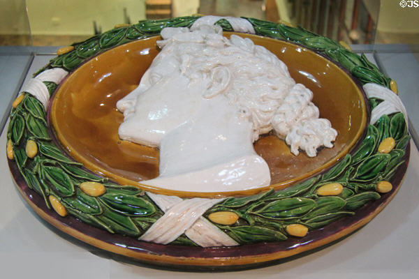 Majolica terracotta roundel of woman's profile surrounded by olive branches (1870s) by Minton of Stoke-upon-Trent at Potteries Museum & Art Gallery. Hanley, Stoke-on-Trent, England.