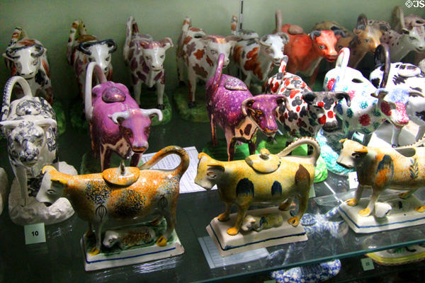 Rows of cow cream jugs with holes in back for filling cream, tails for handles & mouths as pouring spouts at Potteries Museum & Art Gallery. Hanley, Stoke-on-Trent, England.