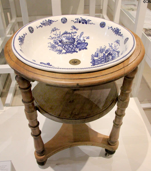 Wedgwood pearlware wash-basin with brass drain on pine stand (1872) at World of Wedgwood. Barlaston, Stoke, England.