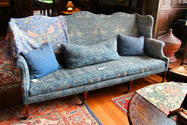 Bird jacquard-woven wool fabric on winged mahogany sofa with undulating top rail (c1890) by Morris & Co in Great Parlor at Wightwick Manor. Wolverhampton, England.