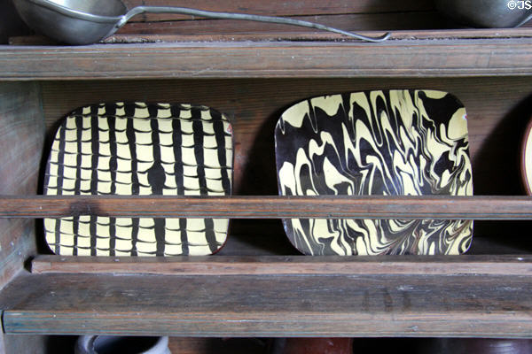 Redware-style plates in brick house at Ulster American Folk Park. Omagh, Northern Ireland.