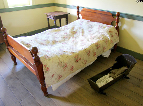 Bed & cradle in brick house at Ulster American Folk Park. Omagh, Northern Ireland.