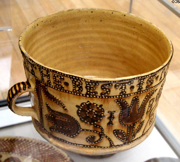 Earthenware slip glazed cup prob. for marriage gift with initials II & IB (1697) made in North Staffordshire at British Museum. London, United Kingdom.