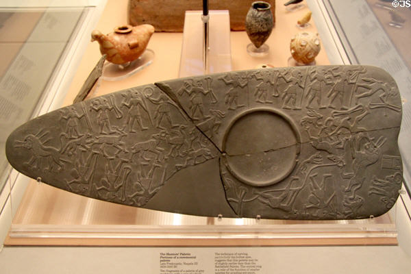 Egyptian predynastic mudstone carved palette for grinding eye paint with hunters' scene (3250-3100 BCE - Naqada III) at British Museum. London, United Kingdom.