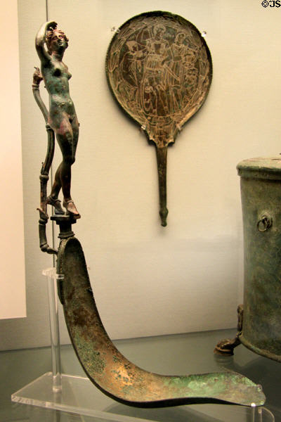 Etruscan bronze skin-scraping strigil with female-figure handle & engraved mirror (c300 BCE) from Palestrina, Latium at British Museum. London, United Kingdom.