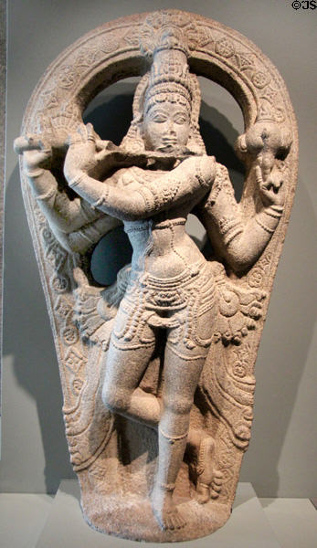Hindu deity Krishna paying flute sculpture (1400-1500) from Tamil Nadu, India at Asian Art Museum. San Francisco, CA.