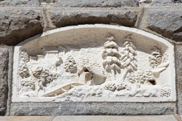 Ponderosa pines & tailrace scene carved on base of James Marshall monument at Marshall Gold Discovery SHP. Coloma, CA.