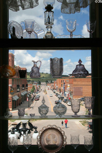 View down Bennett Avenue through glass collection of Cripple Creek District Museum. Cripple Creek, CO.