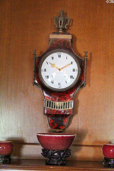 Wall clock with tortoiseshell facings (c1798-1800) from Switzerland over Qing Dynasty oxblood porcelain at Hill-Stead Museum. Farmington, CT.