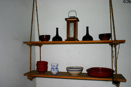 Swinging shelves with glass & pottery objects in Colonial Spanish Quarter Museum. St Augustine, FL.