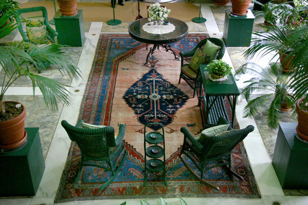 Breakfast table & sitting area with wicker furniture in conservatory at Eastman House. Rochester, NY.