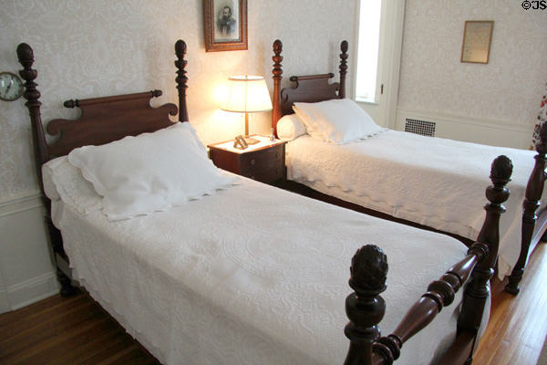Bedroom with carved mahogany low post twin beds with pineapple finials at Eastman House. Rochester, NY.