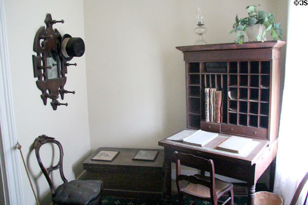 Cubbyhole desk beside hat rack with mirror in Layton Home at Old Bethpage Village. Old Bethpage, NY.
