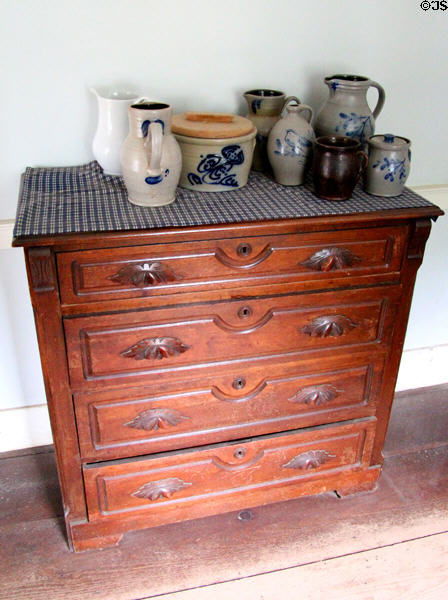 Chest of drawers with stoneware crocks in Powell House at Old Bethpage Village. Old Bethpage, NY.