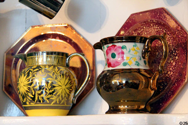 Yellow lusterware pitcher with floral design & copper lusterware pitcher with floral design on white band at Home Sweet Home Museum. East Hampton, NY.