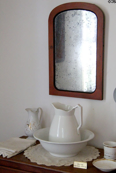 Wash basin & pitcher under mirror in Baetge House at Conservation Plaza. New Braunfels, TX.