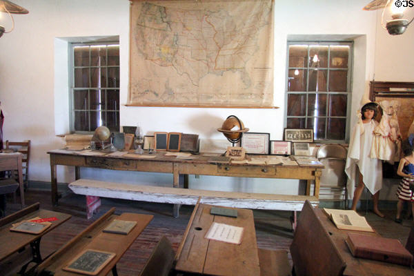 Student desks, writing slate & US map in Church Hill School at Conservation Plaza. New Braunfels, TX.