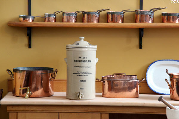 Ceramic water sterilizing filter next to large copper vessel with faucet in kitchen at St Fagans Castle. Cardiff, Wales.