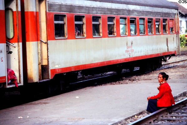 Woman sits on track at rail station. Jogyakarta, Indonesia.
