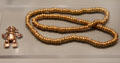 Costa Rica cast gold figure pendant & gold bead necklace from Costa Rica or Panama at Gardiner Museum. Toronto, ON.